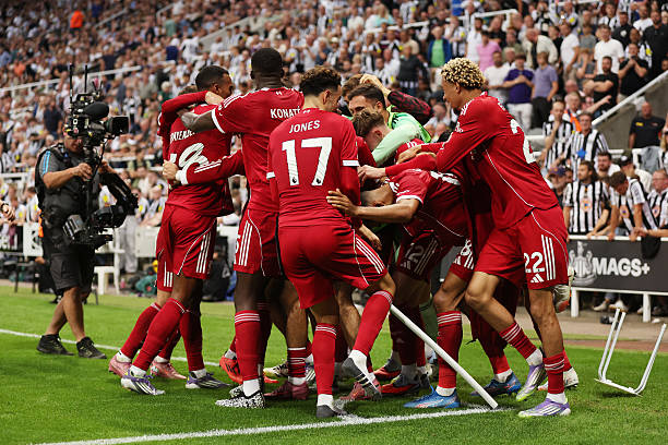 Liverpool players celebrate a late winner in Newcastle.